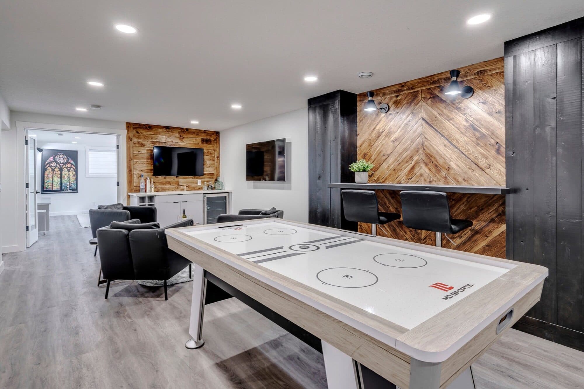 Basement rec room with air hockey table and reclaimed wood bar