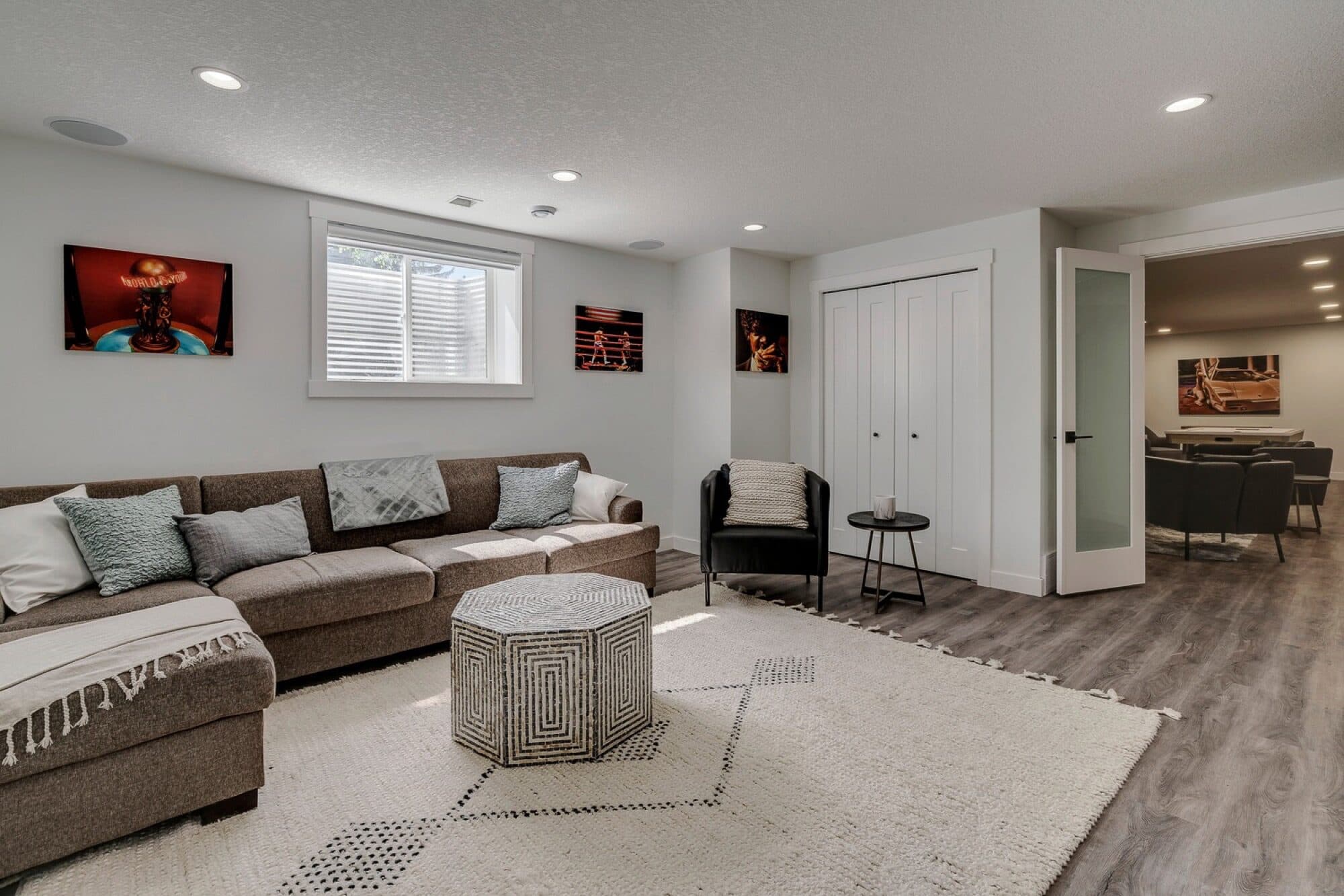 Open-plan basement rec room with sofa and open bar area