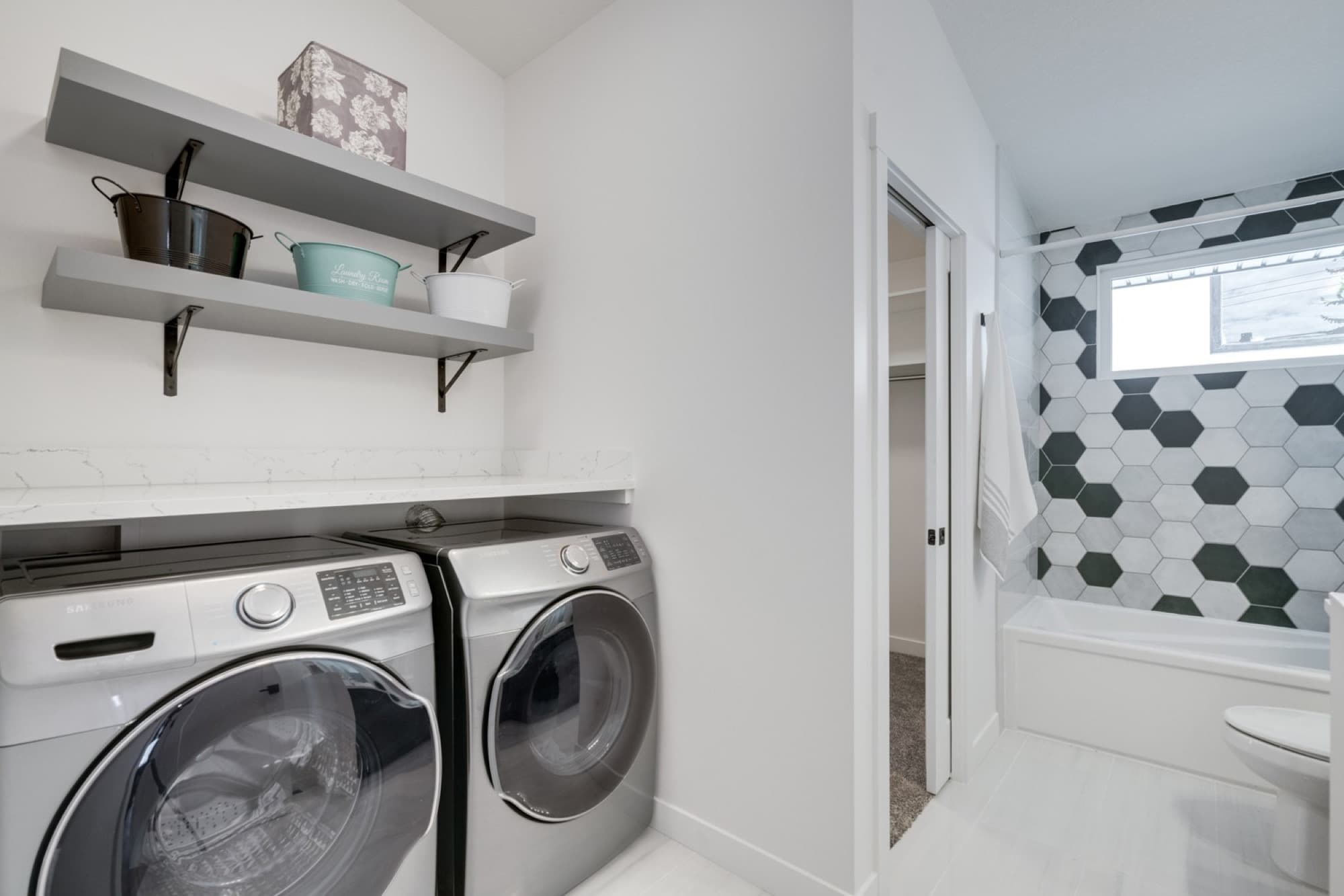 Laundry room with hexagon tile and adjacent bathroom view