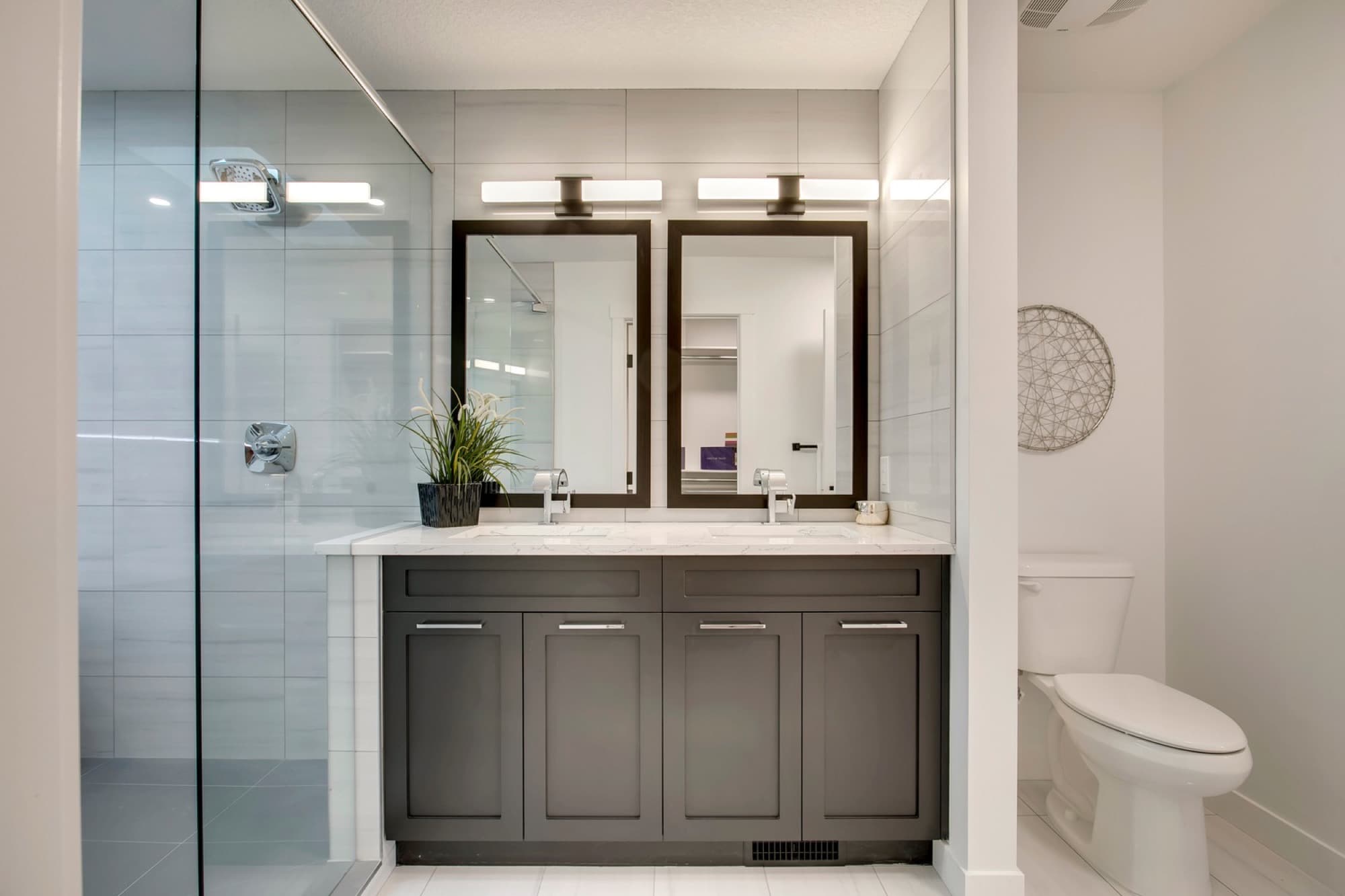Basement bathroom with double vanity and glass shower