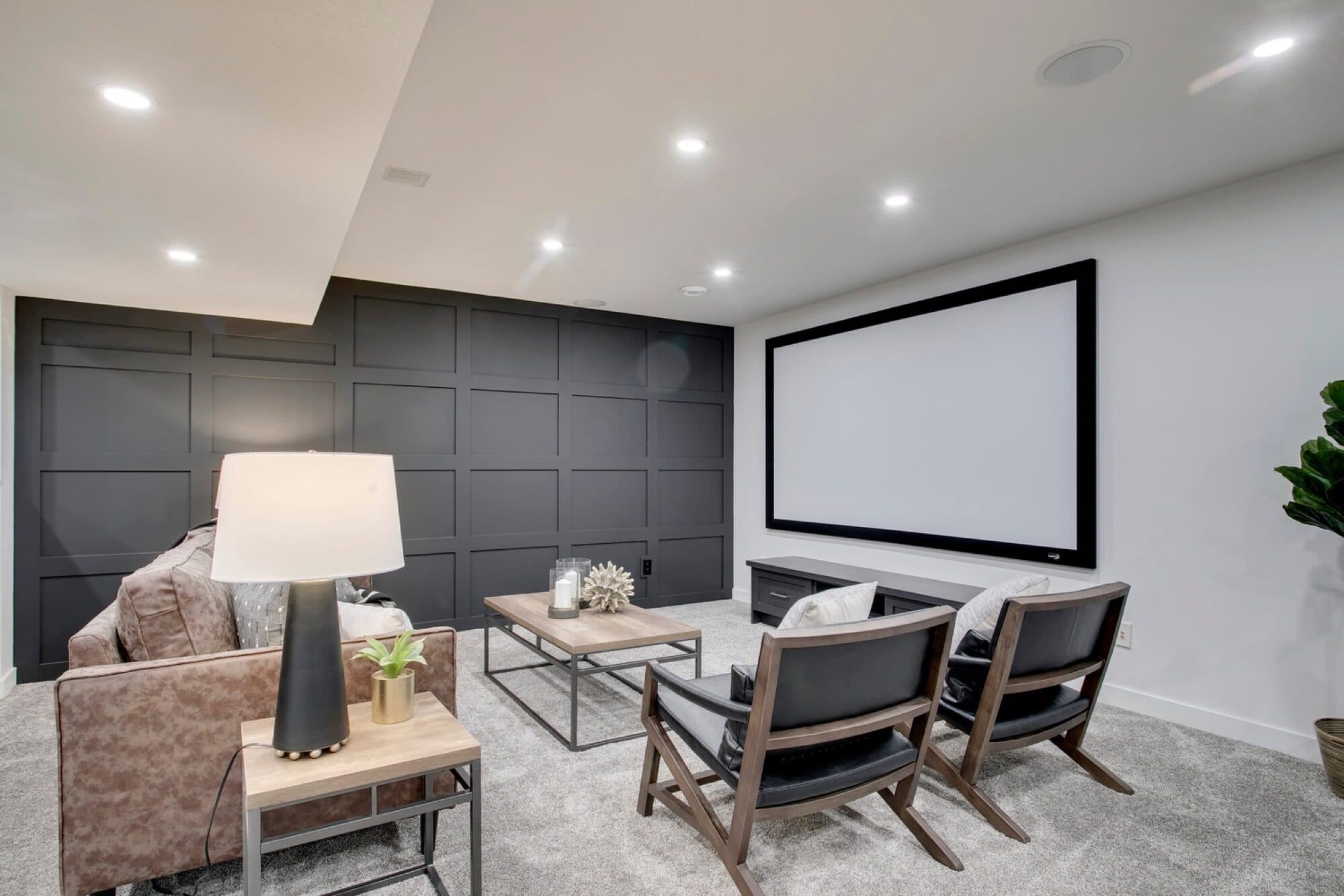 Basement home theatre with projection screen and accent wall