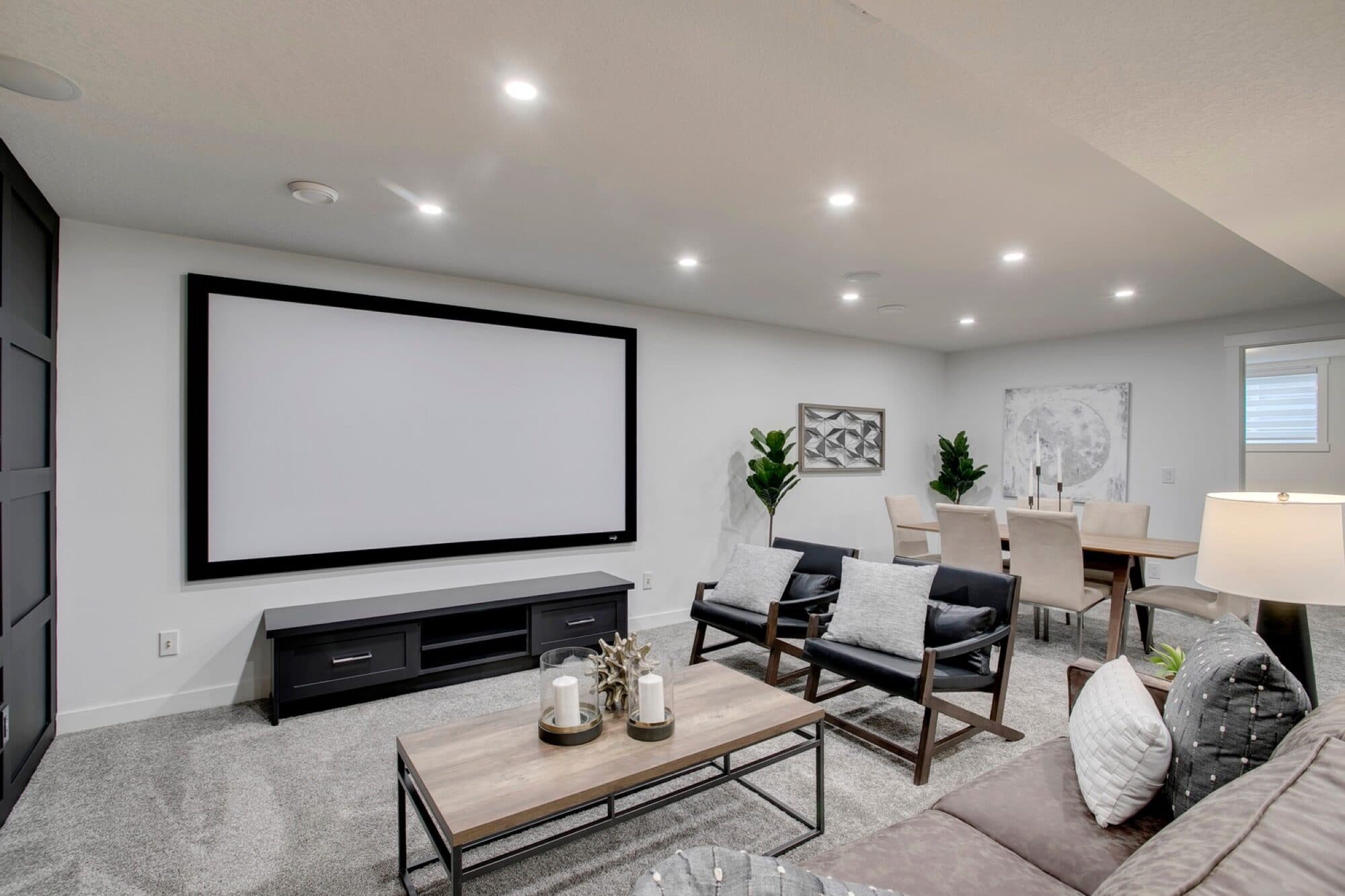 Basement home theatre wide view with projection screen and seating