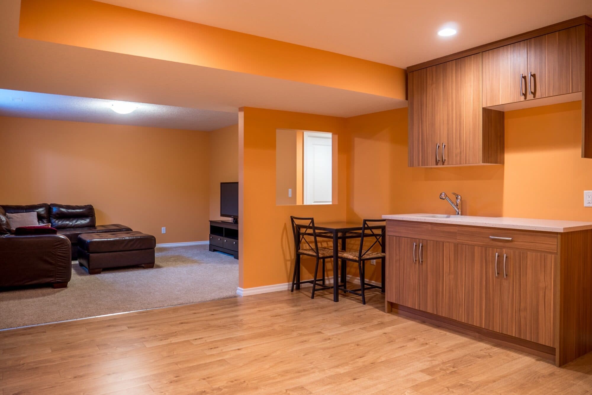 Legal suite with open kitchen and living room in warm tones
