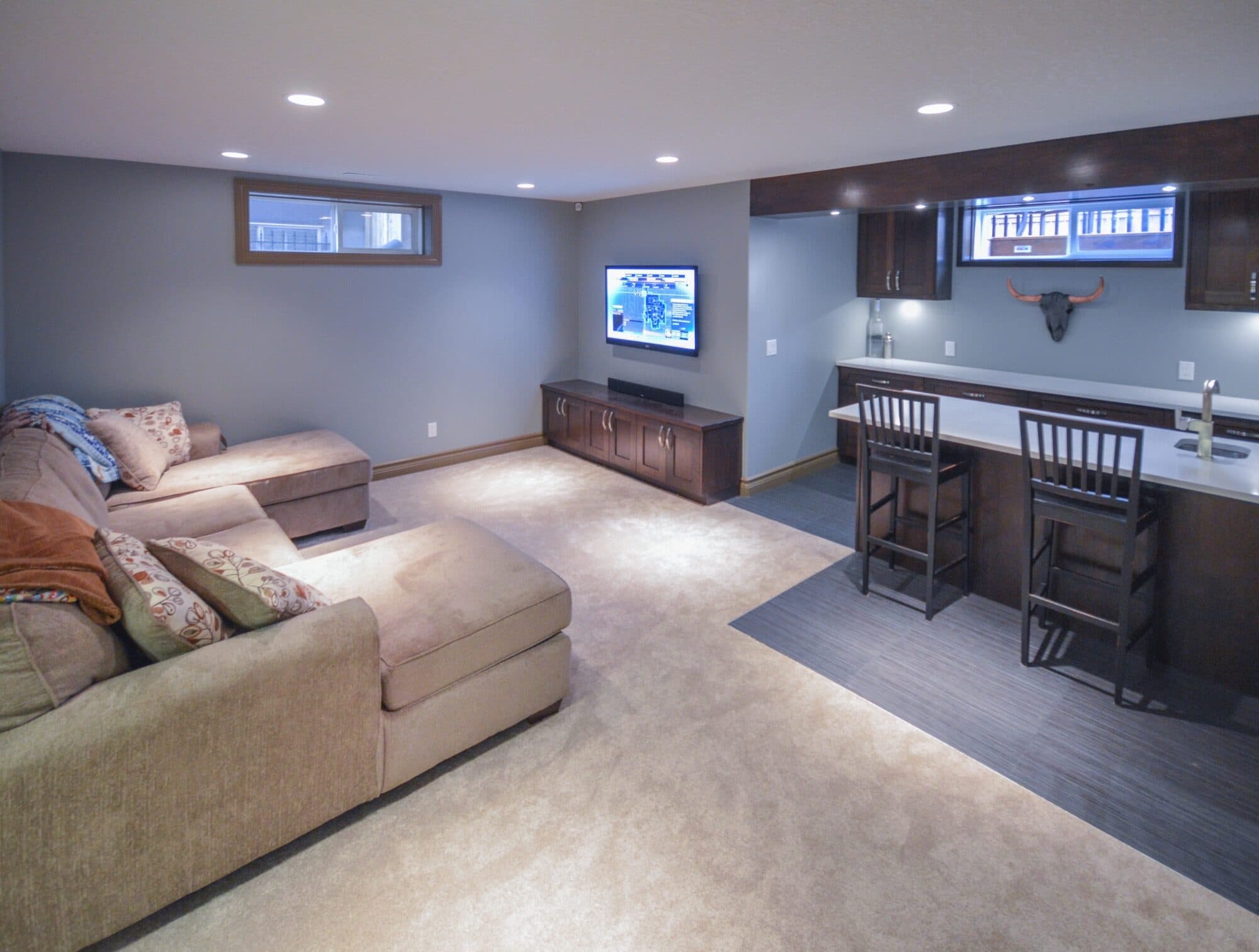 Basement rec room with sectional sofa, TV and bar area