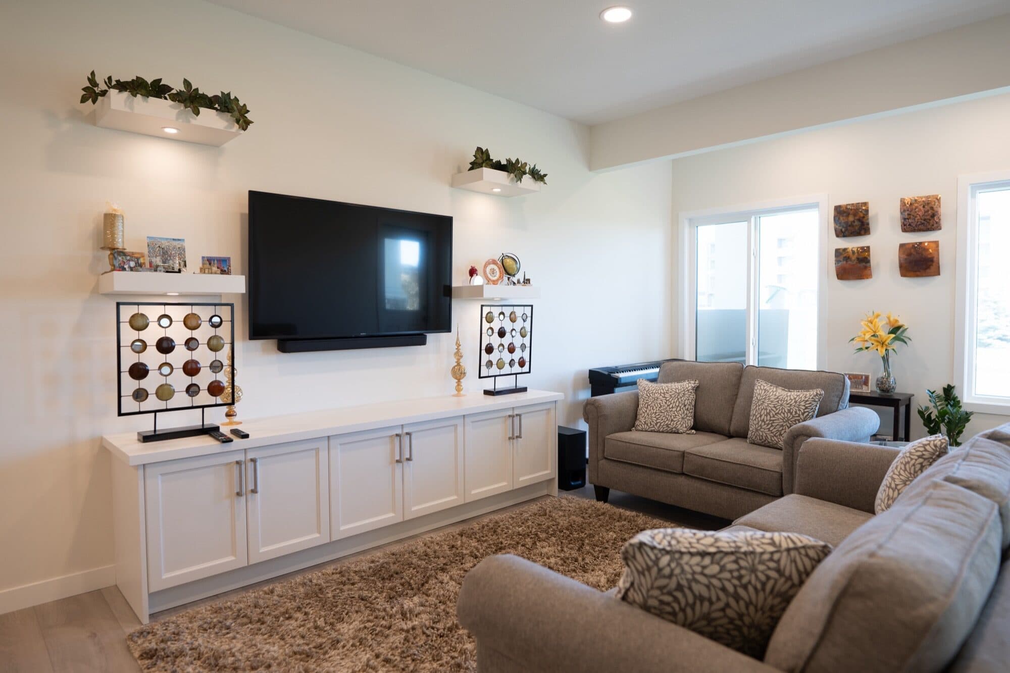 Basement rec room TV wall with built-in cabinetry and seating area