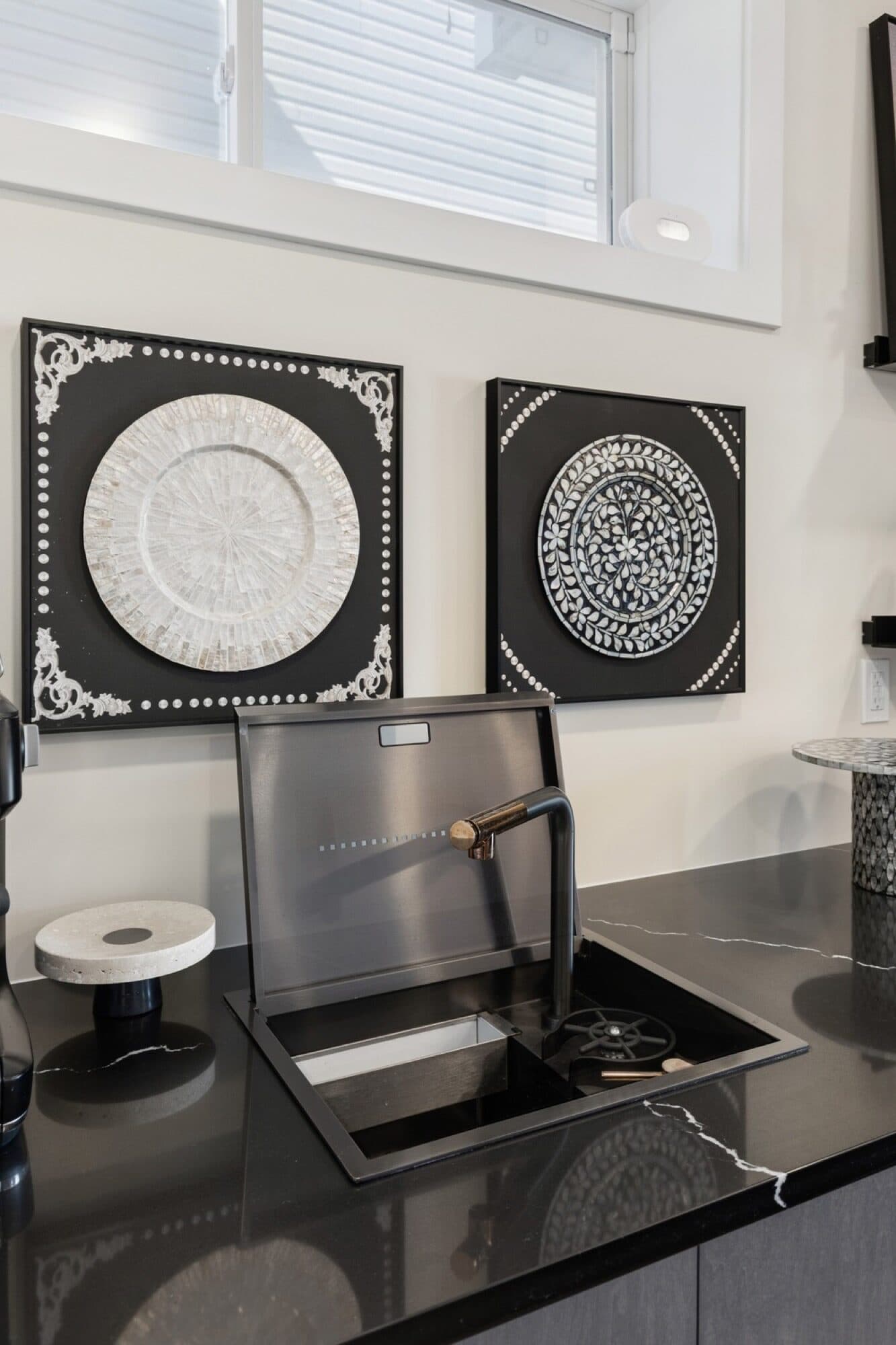 Basement bar detail with black quartz sink, gold faucet and framed art