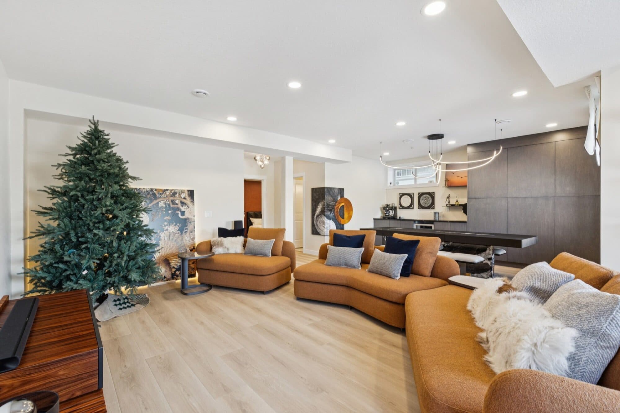 Bright basement living room with curved orange sectional and feature tree niche
