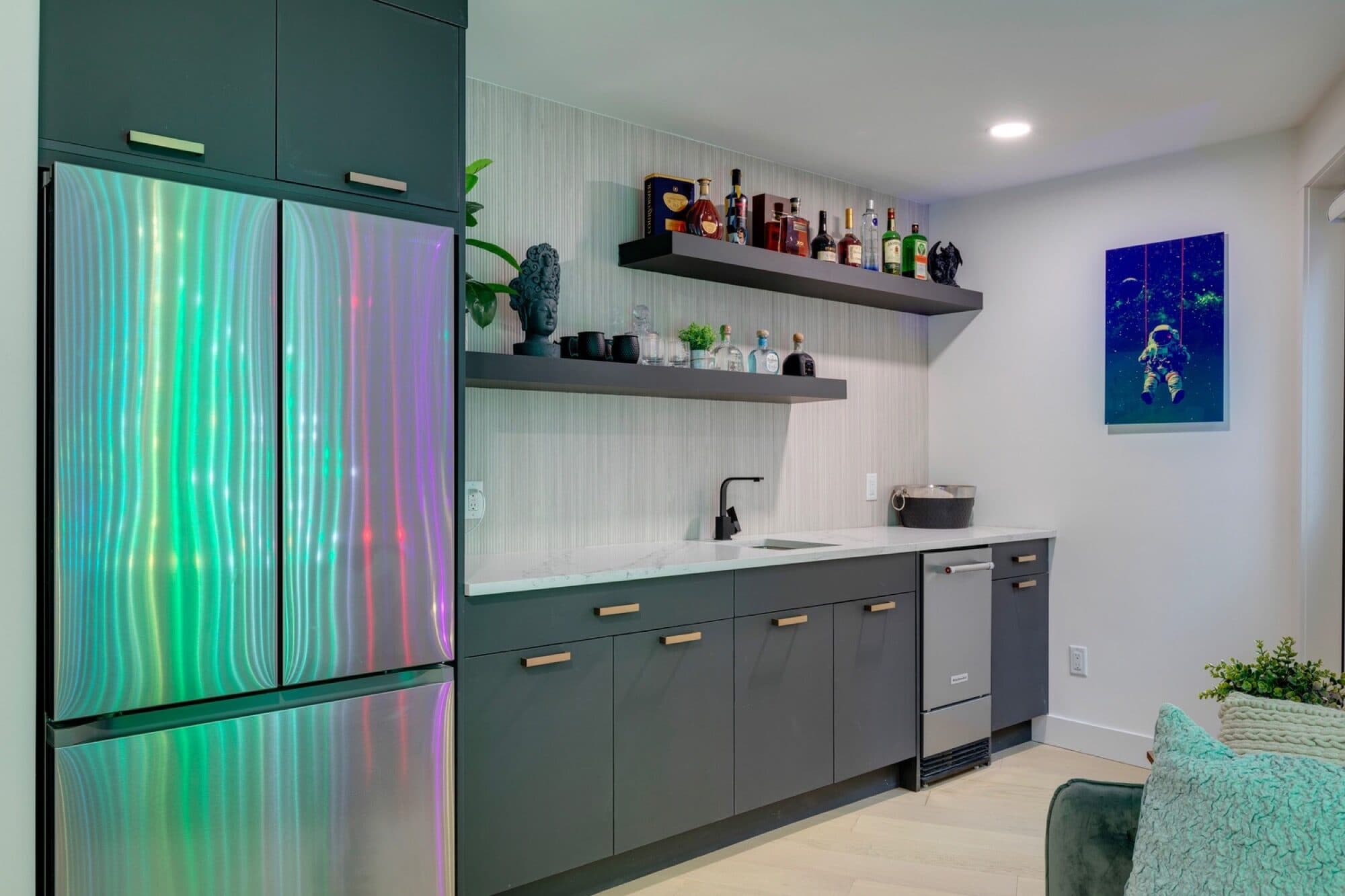 Basement bar with colour-panel fridge, dark shelves and green cabinetry