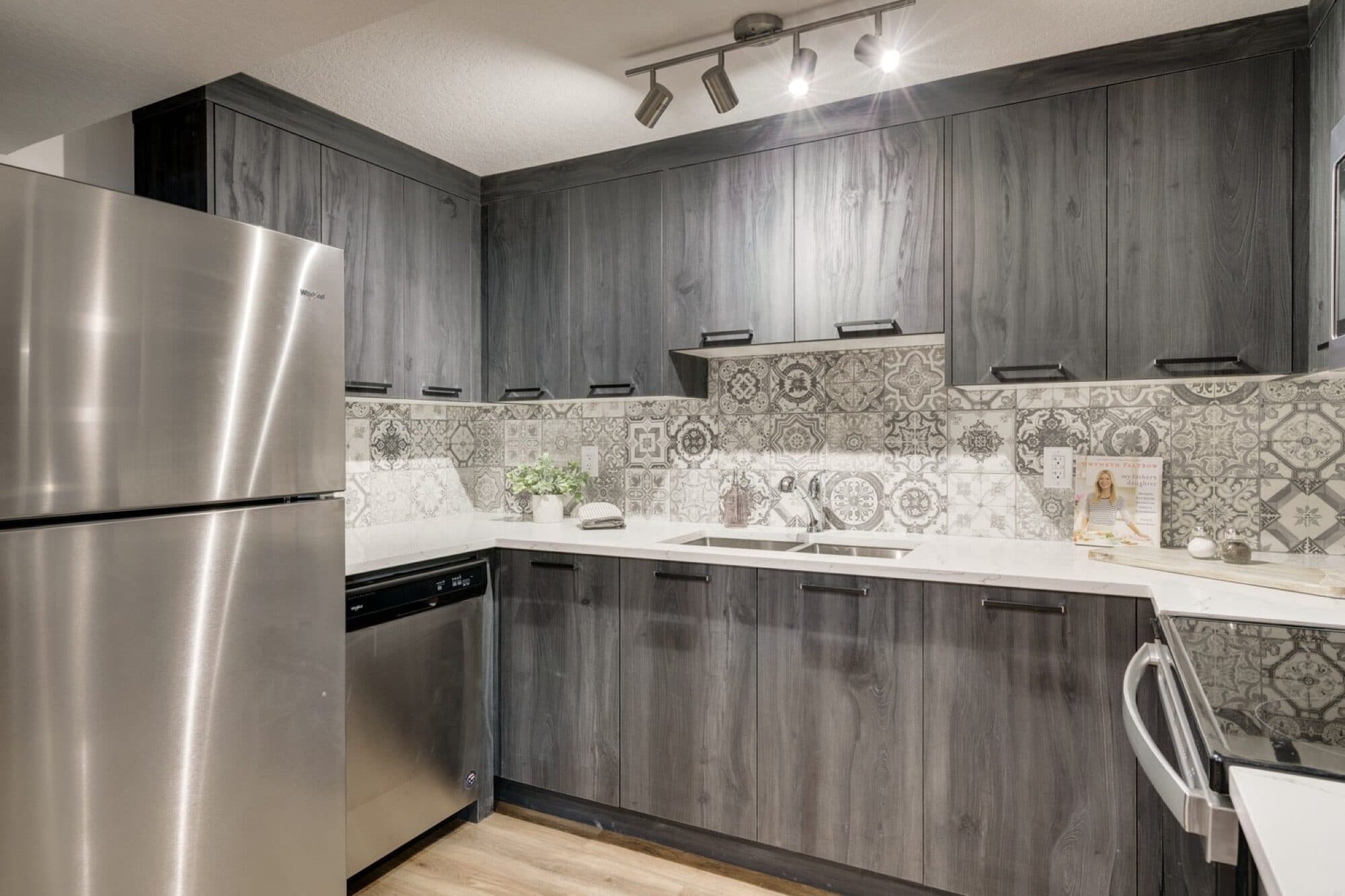 Legal suite kitchen with dark wood cabinets and mosaic backsplash