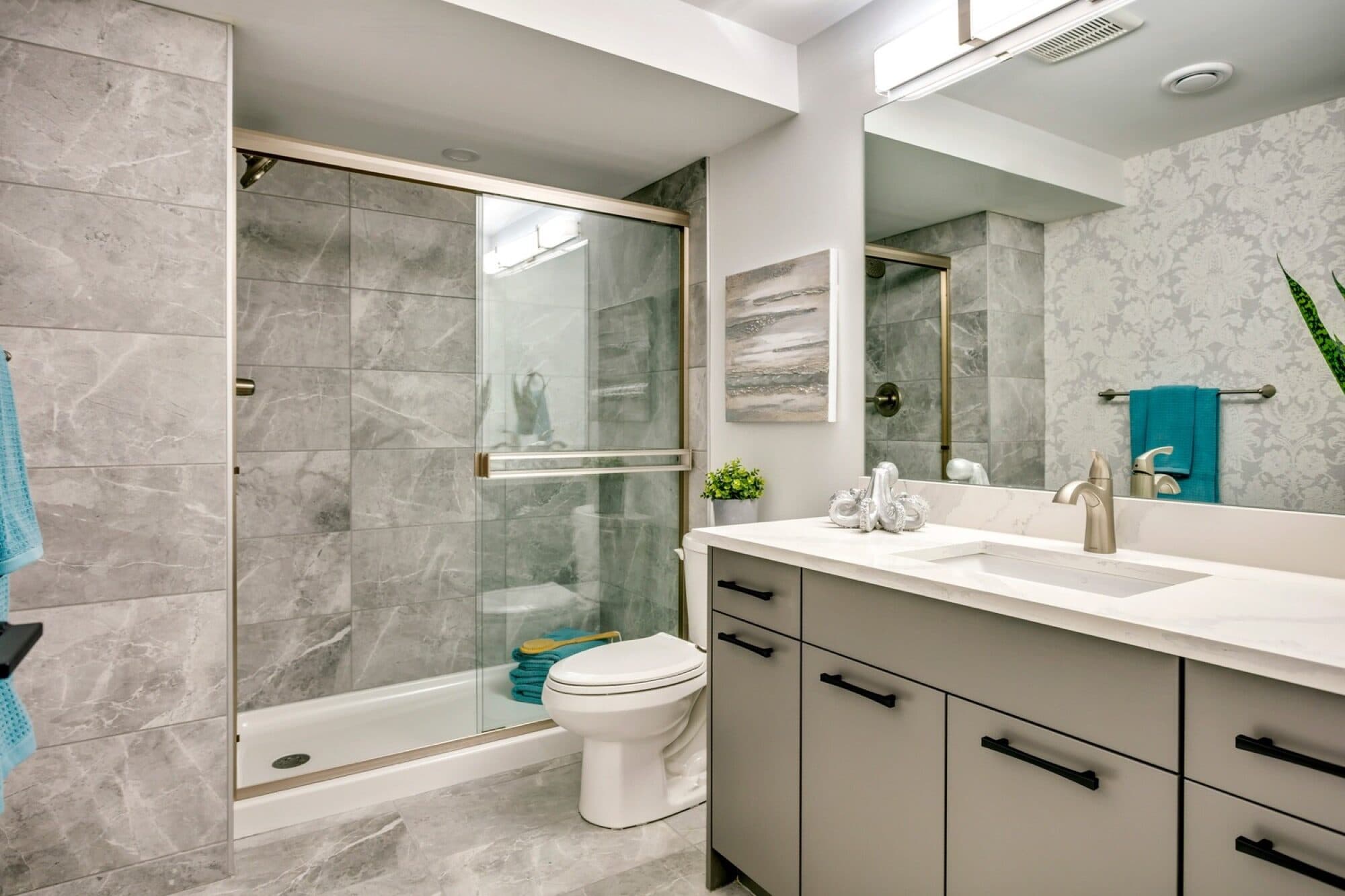 Legal suite bathroom with grey marble tile and glass shower