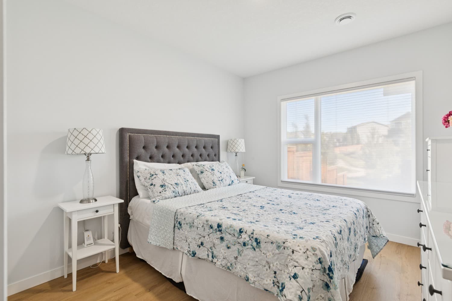 Legal suite bedroom with upholstered headboard and large bright window
