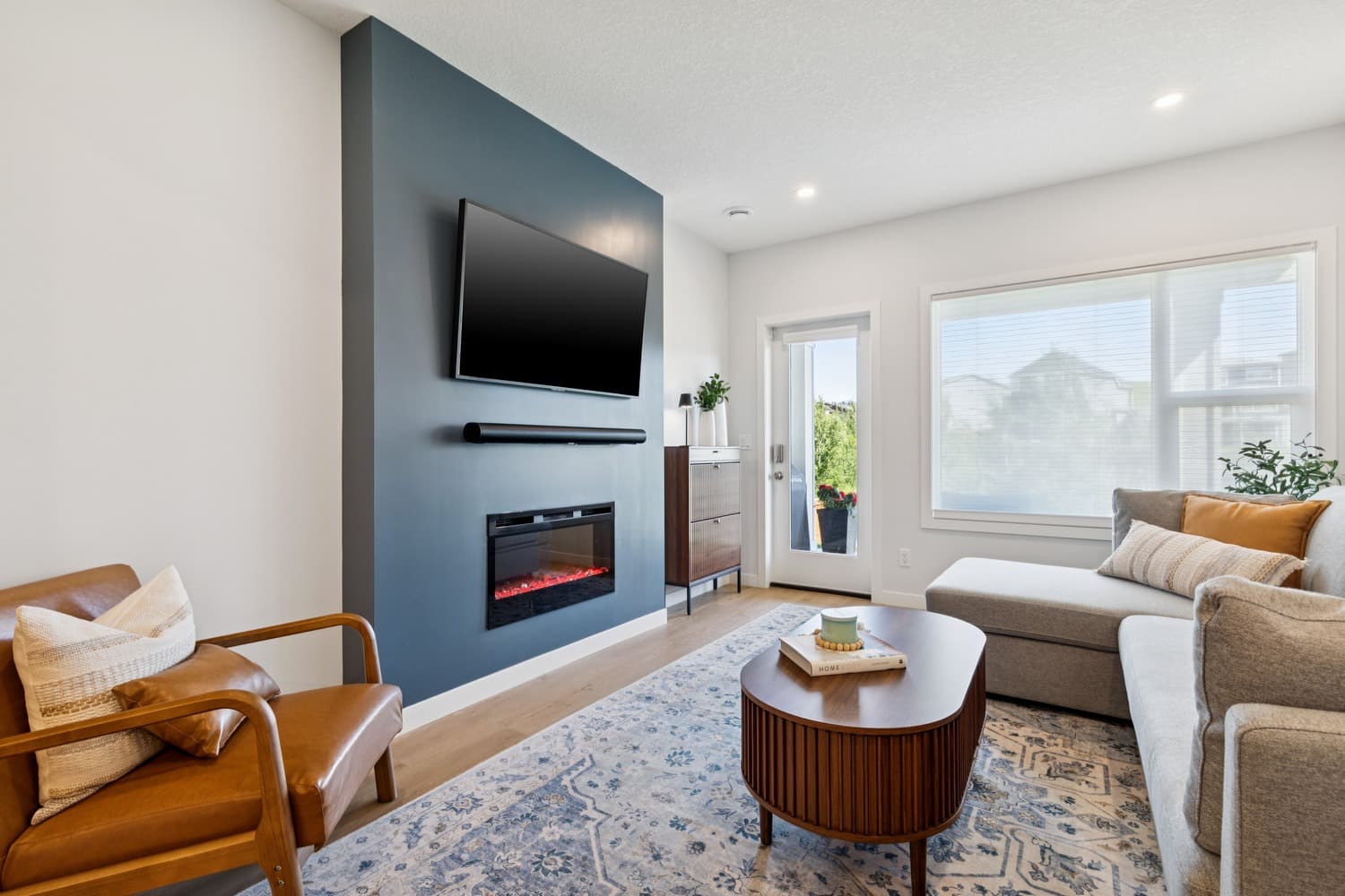 Suite living room with navy feature wall, electric fireplace and TV