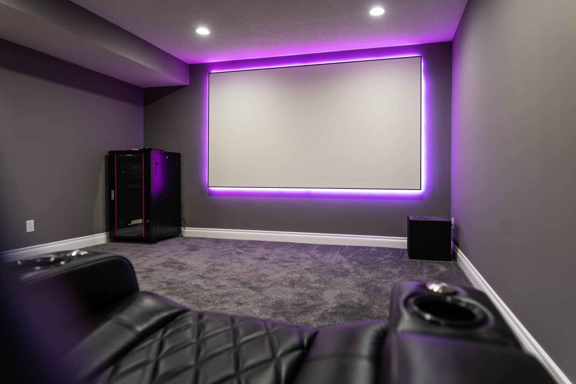 Purple LED home theatre with projection screen and leather recliners