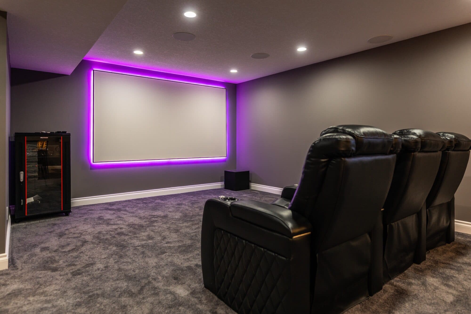 Purple LED home theatre with full recliner row and projection screen