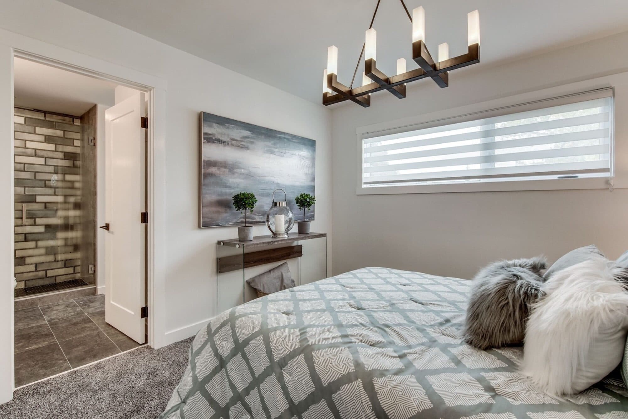 Basement bedroom with chandelier and ensuite hallway view