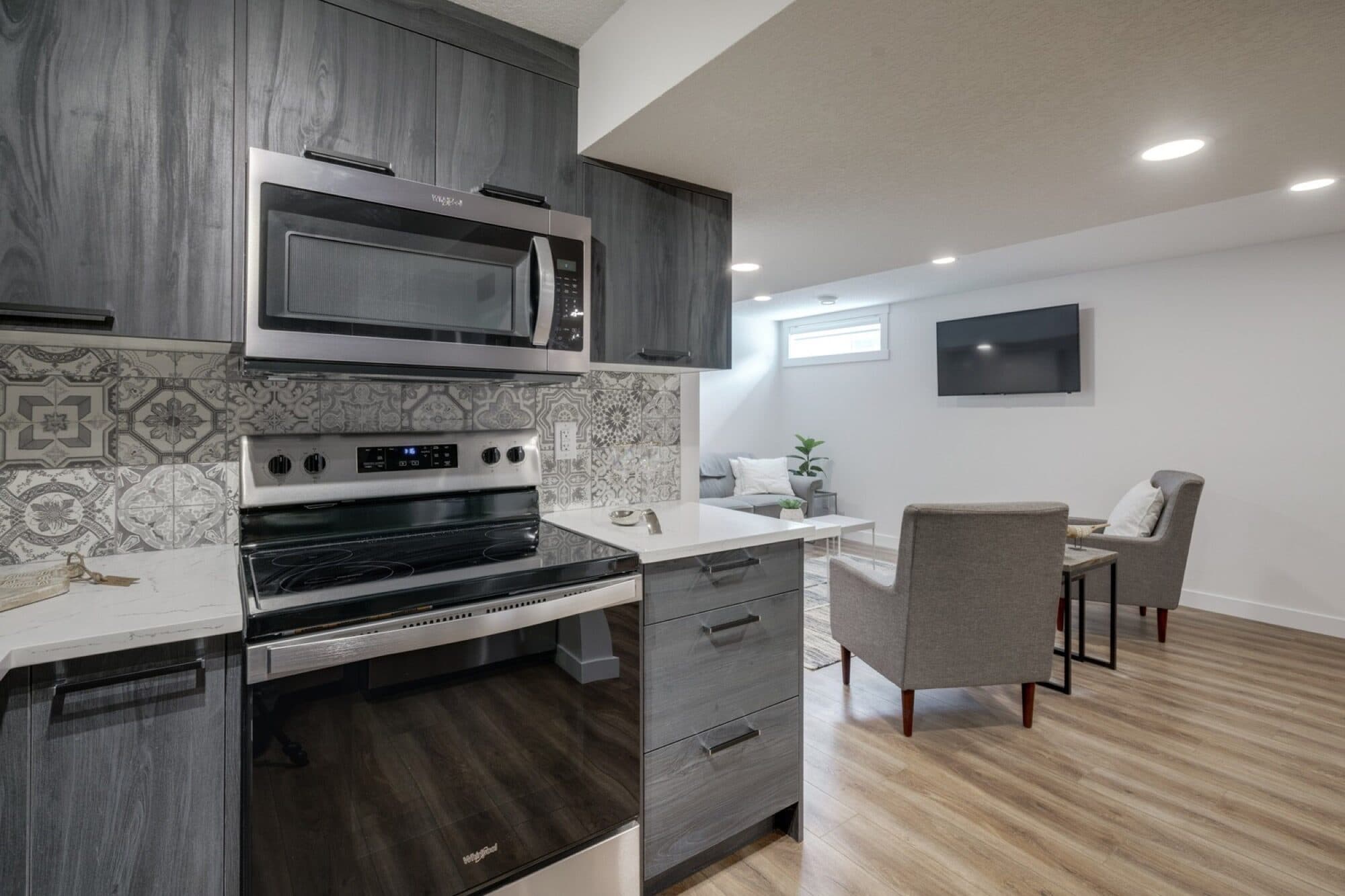 Legal suite kitchen with dark cabinets and patterned backsplash