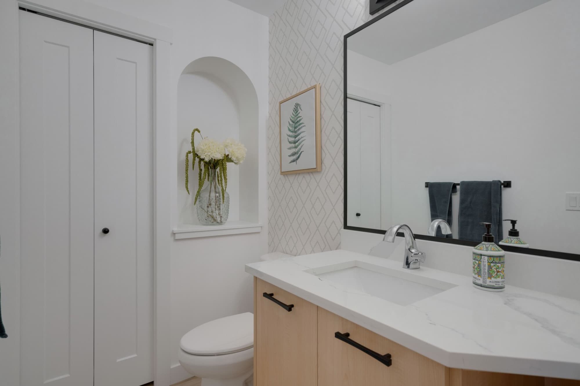 Bathroom with arched niche and geometric wallpaper