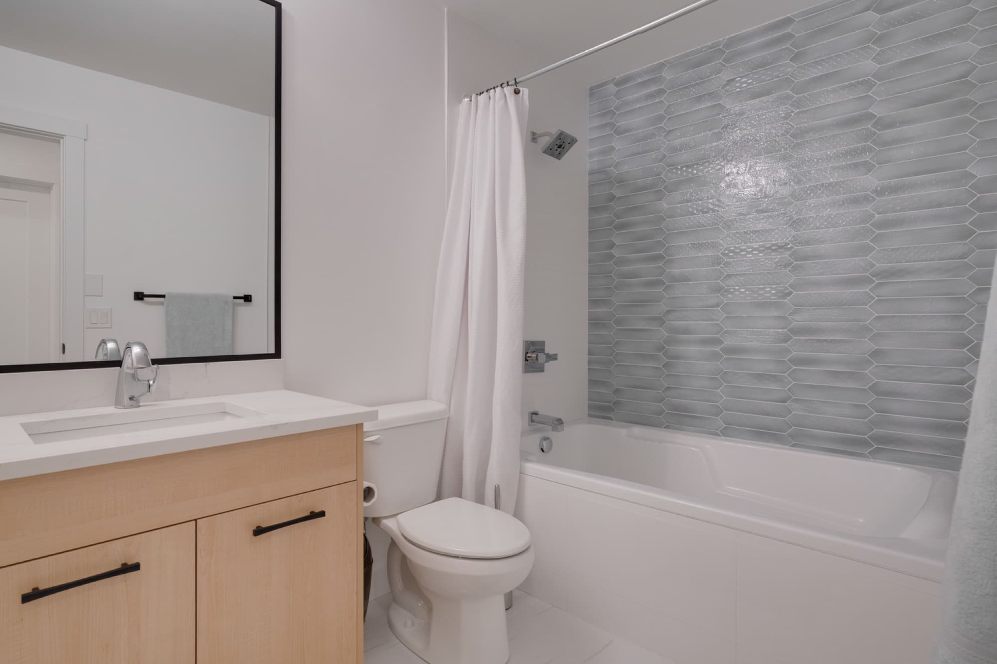 Bathroom with picket glass tile shower and wood vanity