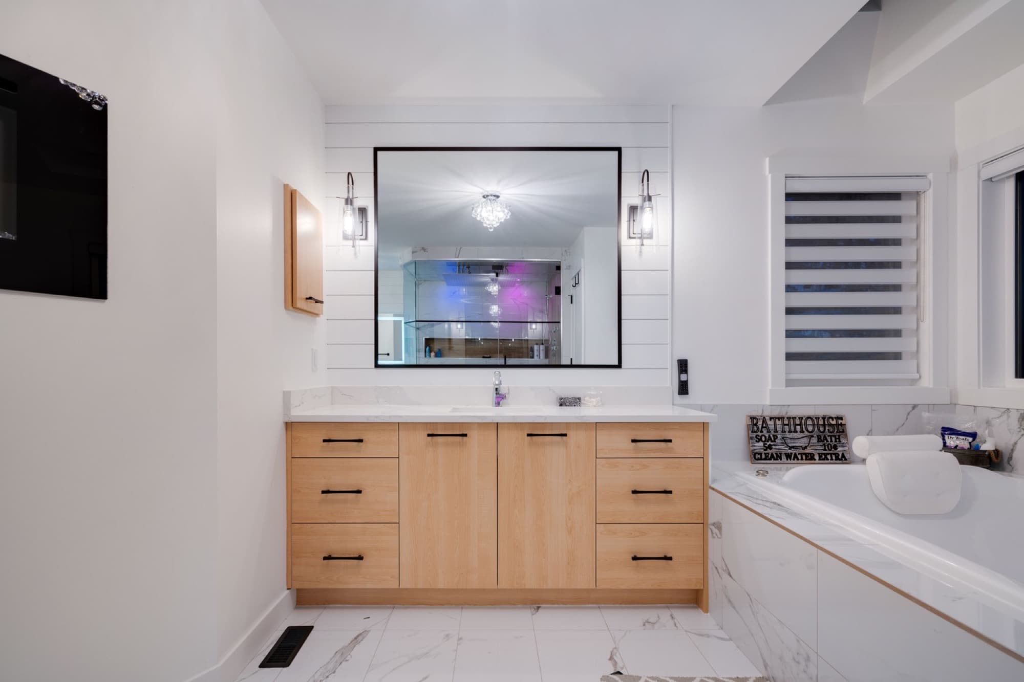 Ensuite double vanity with oak cabinets and marble soaker tub