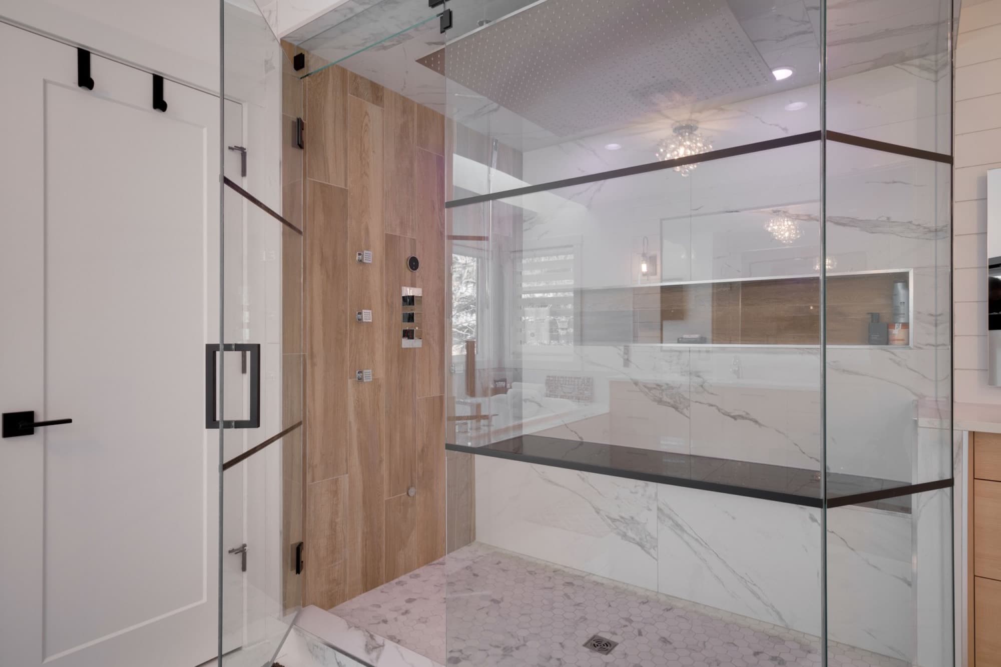 Ensuite glass shower with wood-look tile and built-in bench