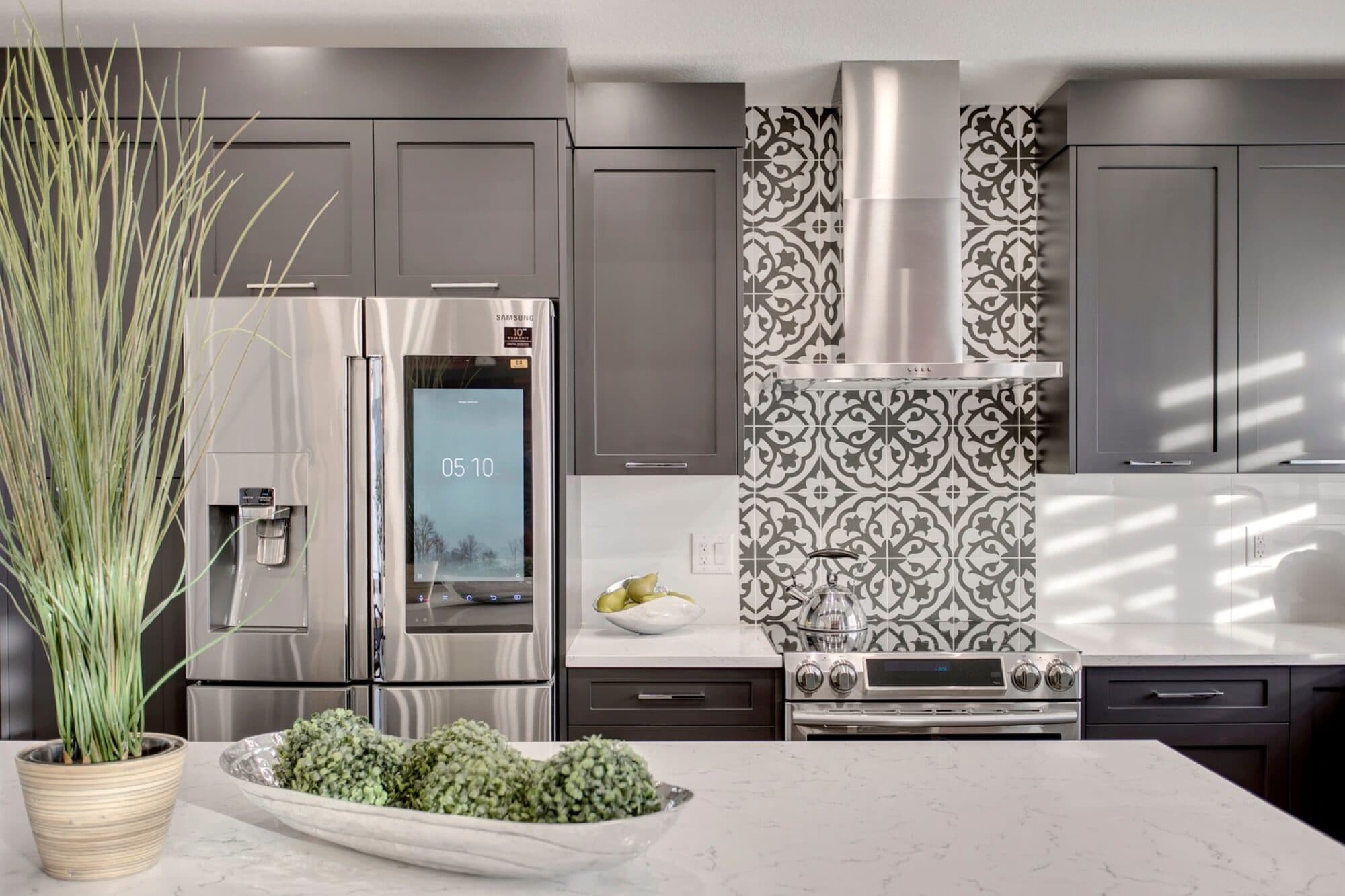 Main-floor kitchen with grey cabinets and patterned backsplash