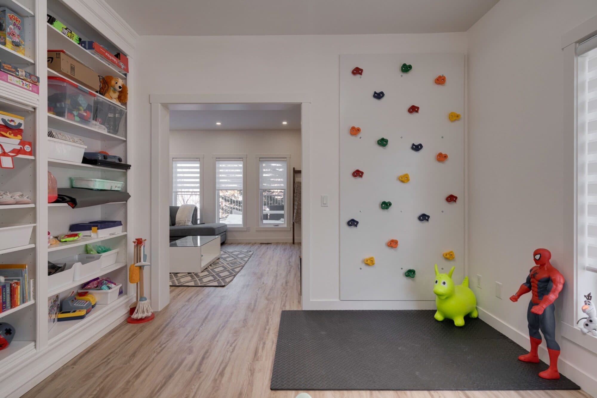 Playroom with indoor climbing wall and toy shelves
