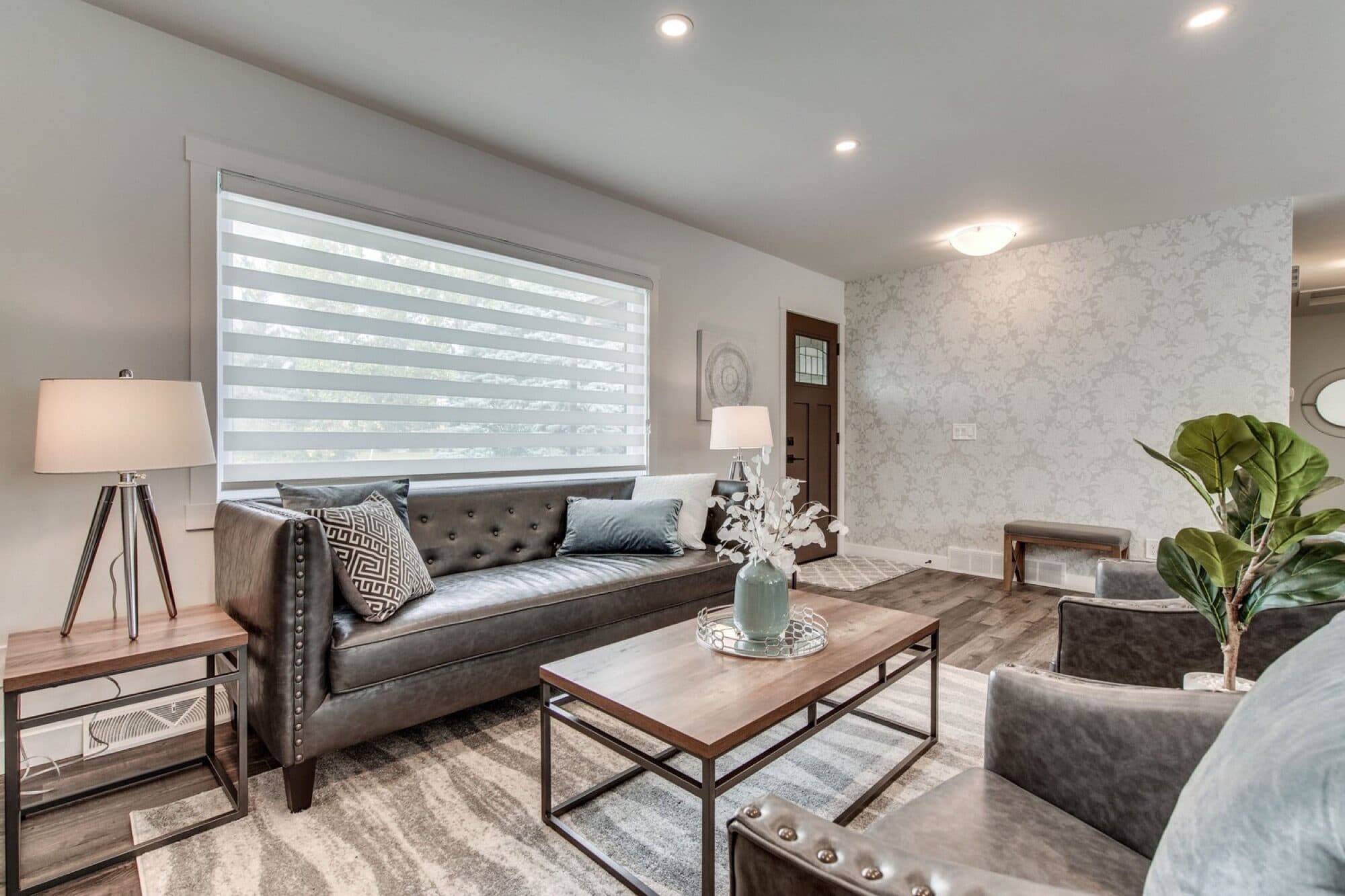 Open main-floor living room with leather sofa and feature wall