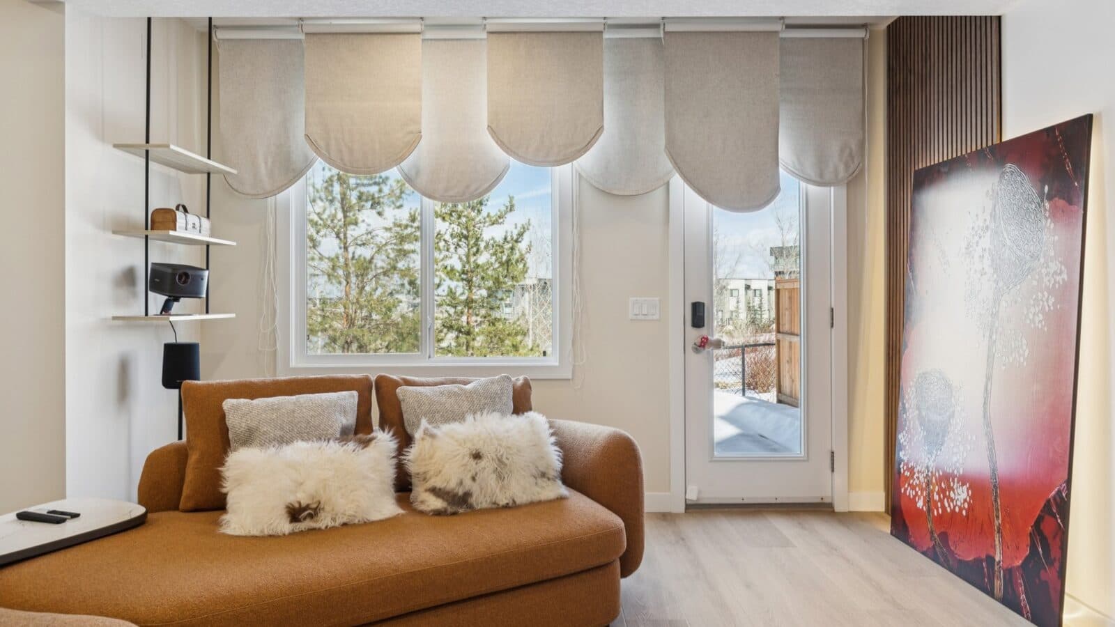 Finished Calgary basement rec room with a sectional sofa, large windows, and a kitchenette.