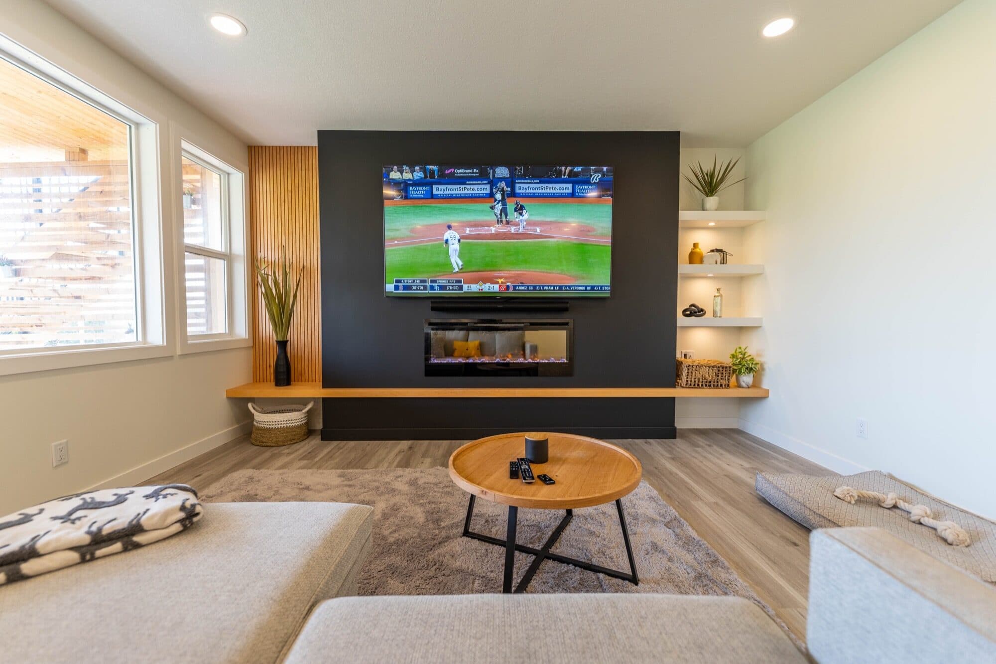 Finished Calgary basement rec room with a media wall, linear fireplace and built-in shelving