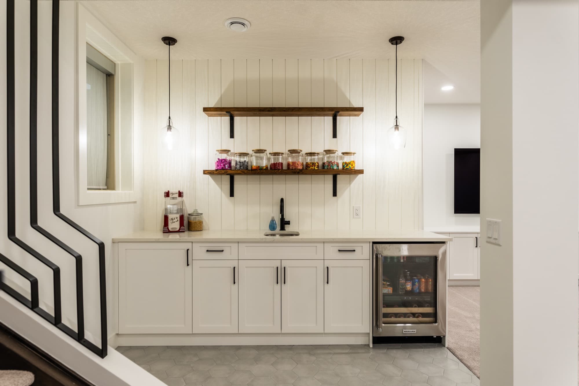 Bright basement snack bar with shiplap wall and beverage fridge in a Calgary basement